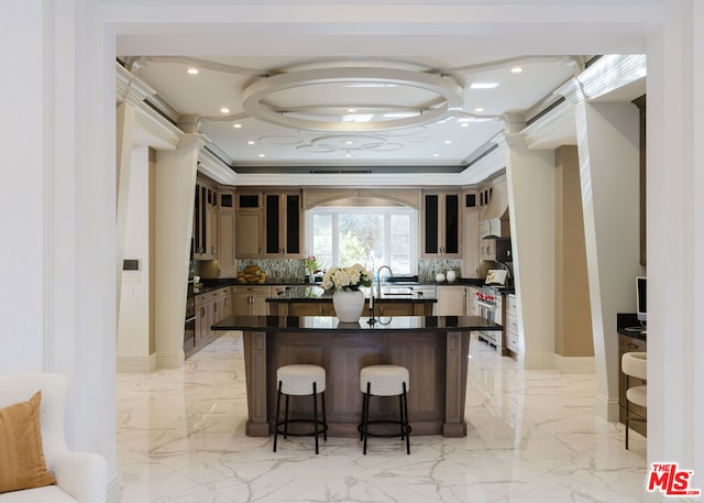 kitchen with decorative backsplash, a kitchen breakfast bar, stainless steel stove, sink, and ornamental molding