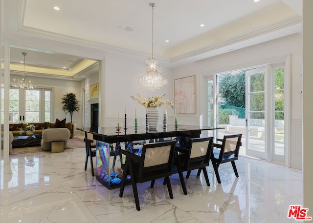 dining room with french doors, a tray ceiling, a chandelier, and ornamental molding