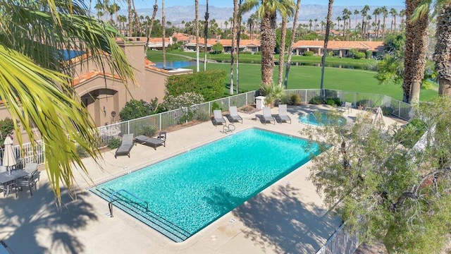 view of swimming pool with a lawn, a mountain view, and a patio