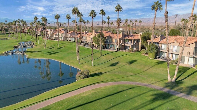 view of property's community featuring a lawn and a water and mountain view