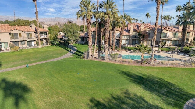 view of community with a lawn and a mountain view