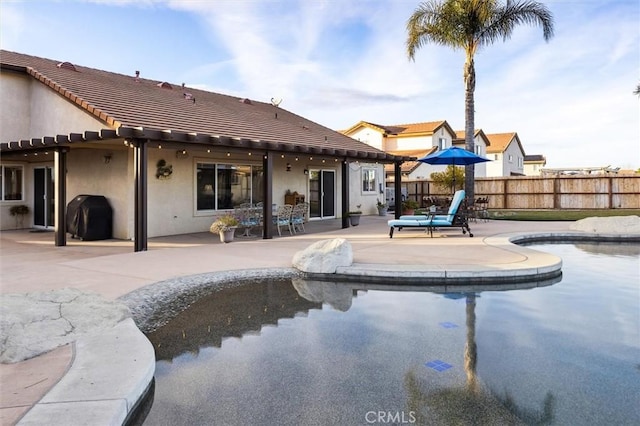 view of swimming pool featuring a grill and a patio