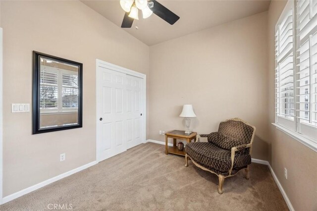 living area with ceiling fan and light colored carpet