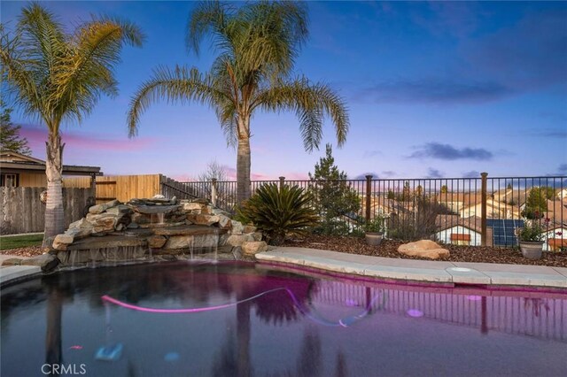 view of pool at dusk