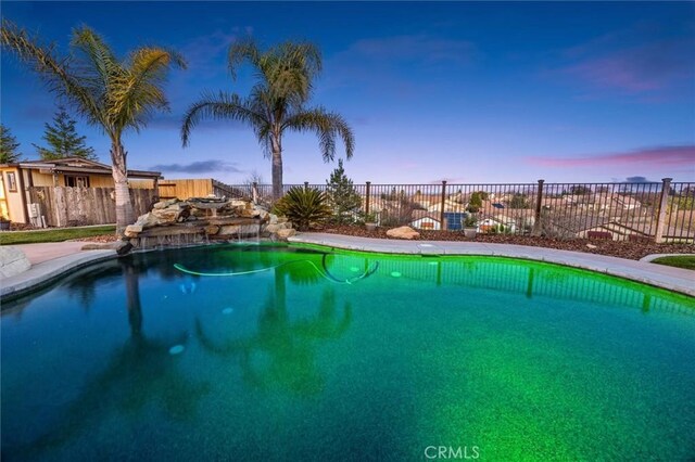 view of pool at dusk