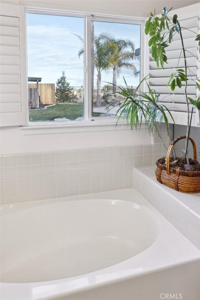 bathroom featuring a healthy amount of sunlight and a tub