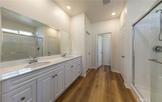 bathroom with a shower with door, wood-type flooring, and vanity