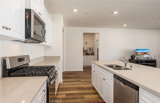 kitchen with dark hardwood / wood-style flooring, sink, stainless steel appliances, and white cabinetry