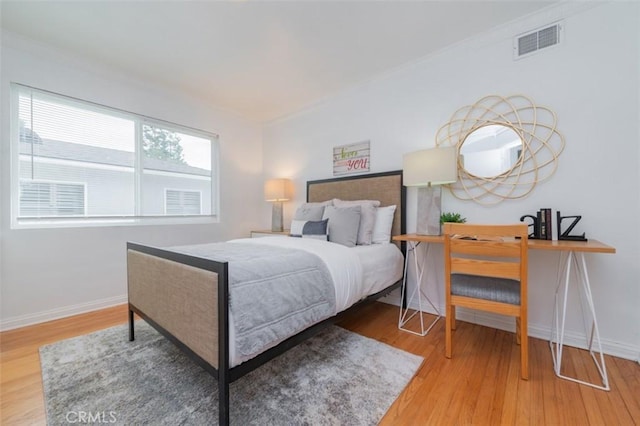 bedroom with wood-type flooring and crown molding