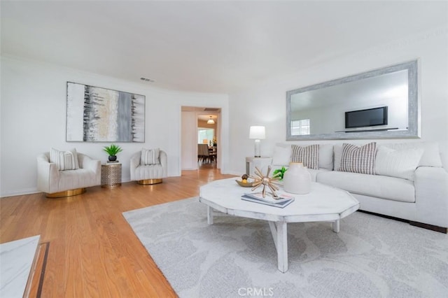 living room with crown molding and hardwood / wood-style flooring