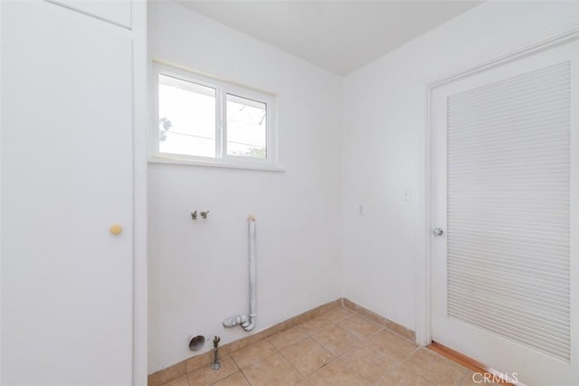 clothes washing area featuring hookup for a gas dryer and light tile patterned floors