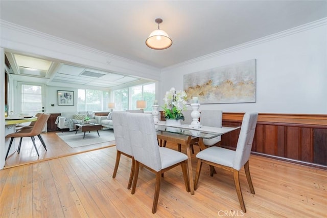 dining space featuring light wood-type flooring and ornamental molding