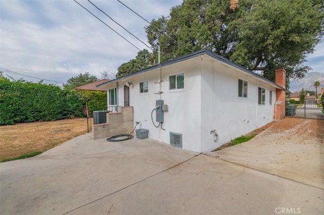 view of side of home featuring cooling unit and a patio