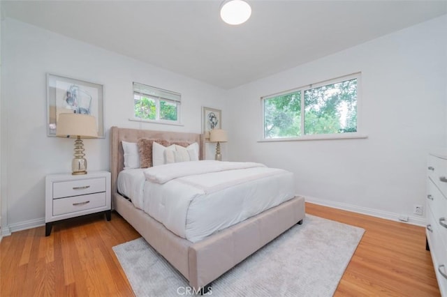 bedroom featuring multiple windows and light wood-type flooring