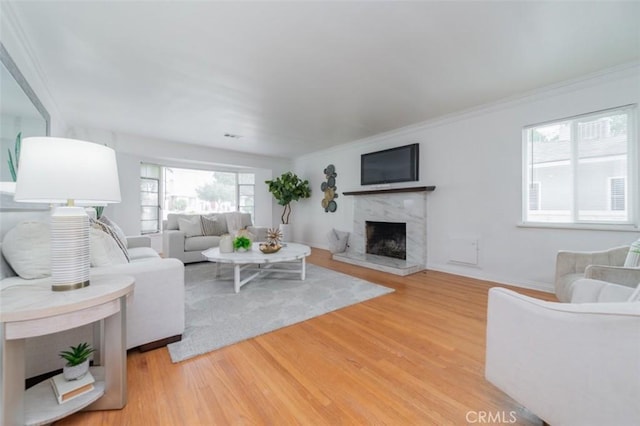 living room with ornamental molding, a fireplace, and wood-type flooring