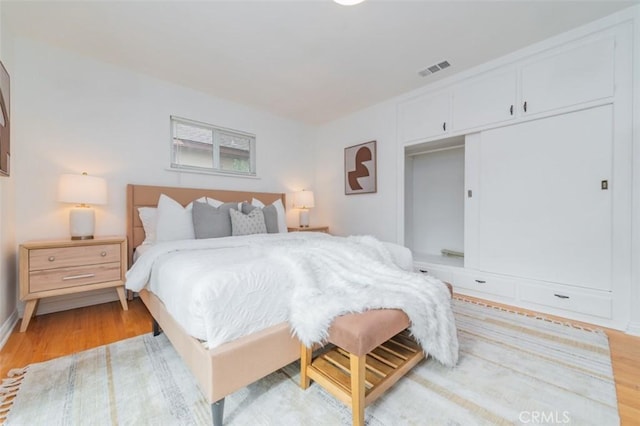 bedroom with light hardwood / wood-style flooring and a closet