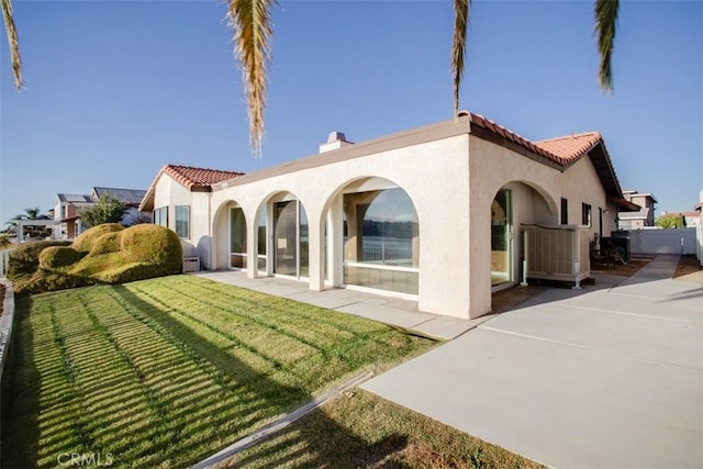 rear view of house with a patio area and a lawn