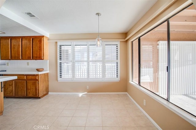 kitchen with pendant lighting, light tile patterned floors, and tasteful backsplash