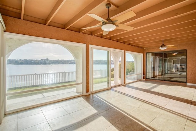 unfurnished sunroom with ceiling fan, a water view, and vaulted ceiling with beams