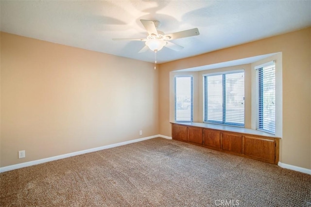 unfurnished room with ceiling fan and carpet flooring