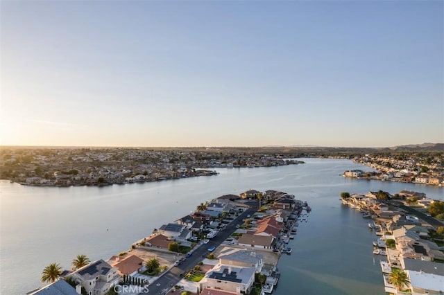 aerial view at dusk featuring a water view