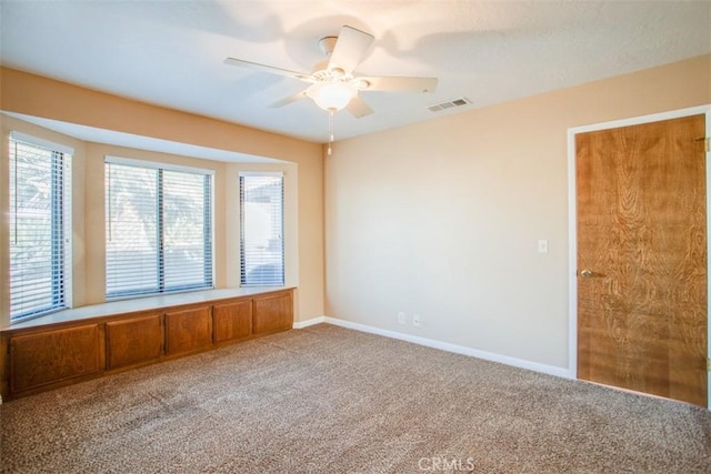 carpeted spare room with ceiling fan