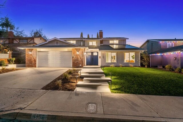 view of front of property with a yard and a garage