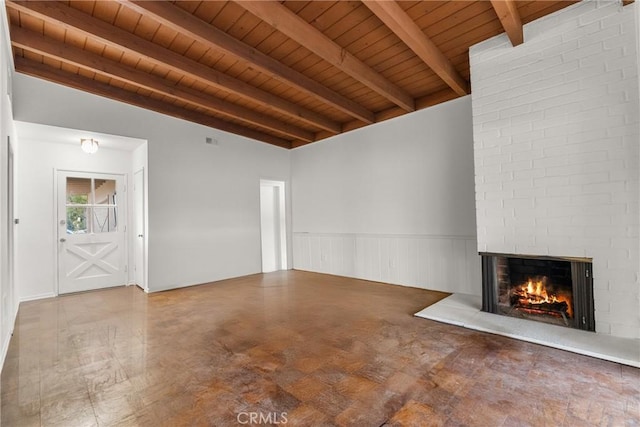 unfurnished living room with a multi sided fireplace, lofted ceiling with beams, and wooden ceiling