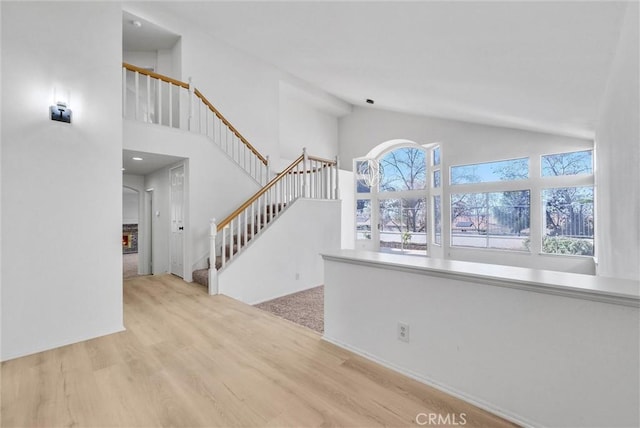 interior space featuring light hardwood / wood-style floors and high vaulted ceiling