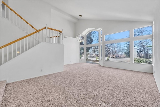 unfurnished living room featuring carpet floors and a high ceiling