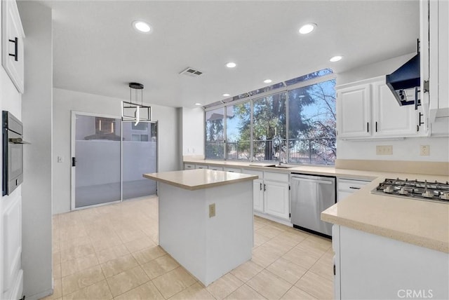 kitchen featuring white cabinets, hanging light fixtures, appliances with stainless steel finishes, and a kitchen island