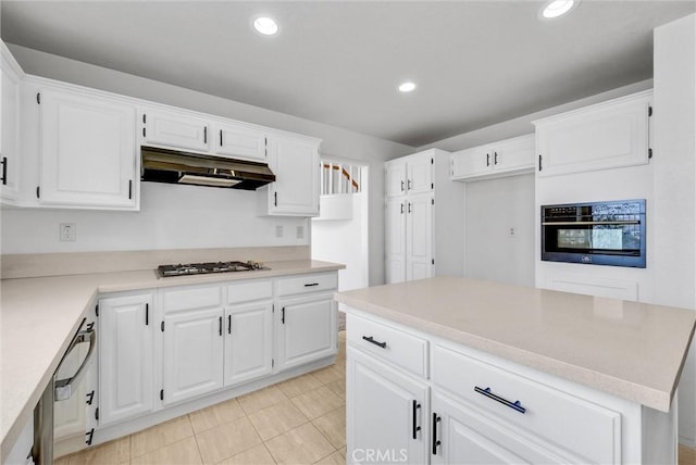 kitchen with white cabinets, a center island, oven, light tile patterned floors, and stainless steel gas stovetop