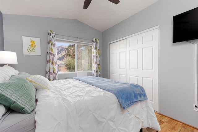 bedroom with hardwood / wood-style flooring, lofted ceiling, ceiling fan, and a closet