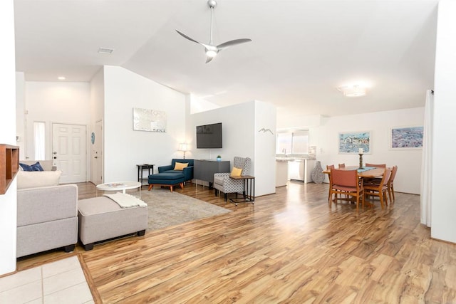 living room featuring high vaulted ceiling, ceiling fan, and light hardwood / wood-style flooring