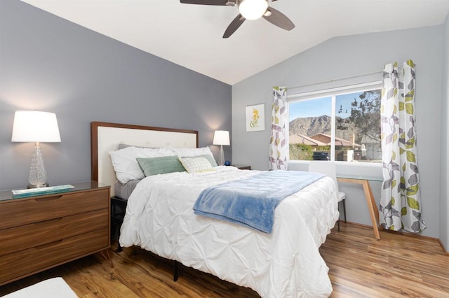 bedroom featuring hardwood / wood-style floors, vaulted ceiling, and ceiling fan