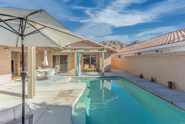 view of pool with a mountain view and a patio area