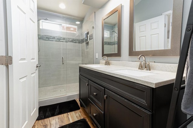 bathroom featuring wood-type flooring, an enclosed shower, and vanity