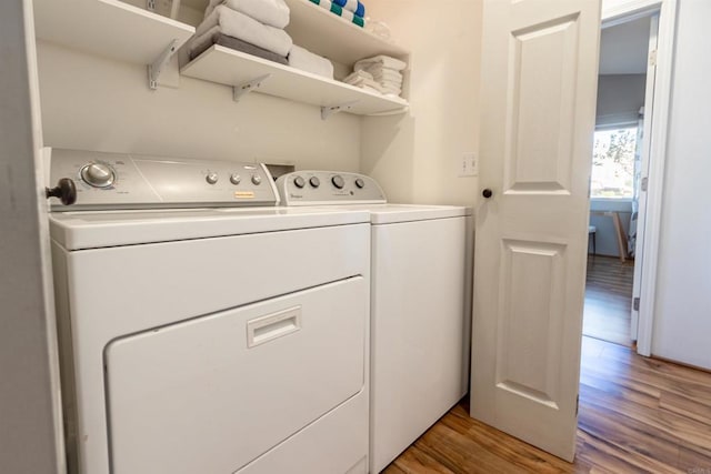 clothes washing area featuring laundry area, independent washer and dryer, and light wood-style floors