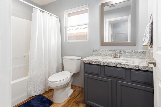 bathroom with toilet, wood finished floors, visible vents, vanity, and shower / bathtub combination with curtain