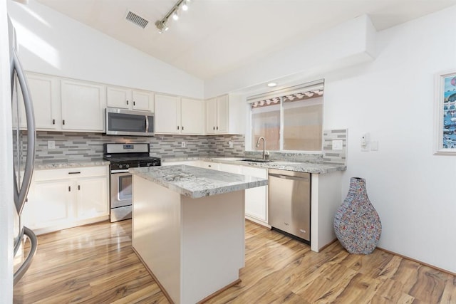 kitchen featuring visible vents, appliances with stainless steel finishes, vaulted ceiling, and decorative backsplash