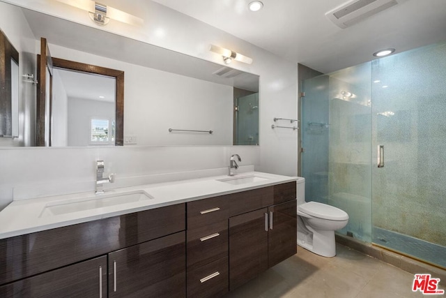 bathroom featuring toilet, vanity, and a shower with door