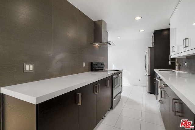 kitchen featuring electric range, sink, stainless steel refrigerator, white cabinetry, and island range hood