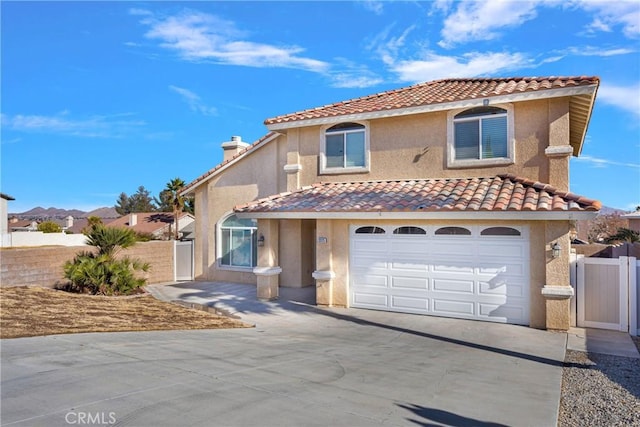 mediterranean / spanish house featuring a gate, stucco siding, and fence