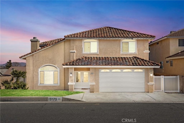 view of front of home featuring stucco siding, concrete driveway, a garage, and fence