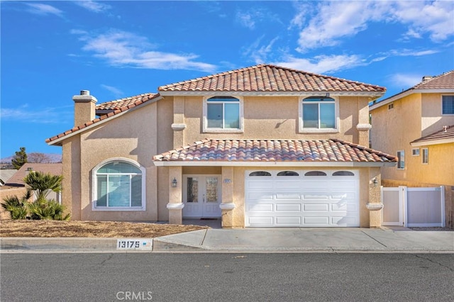 mediterranean / spanish house with french doors, stucco siding, a chimney, and fence