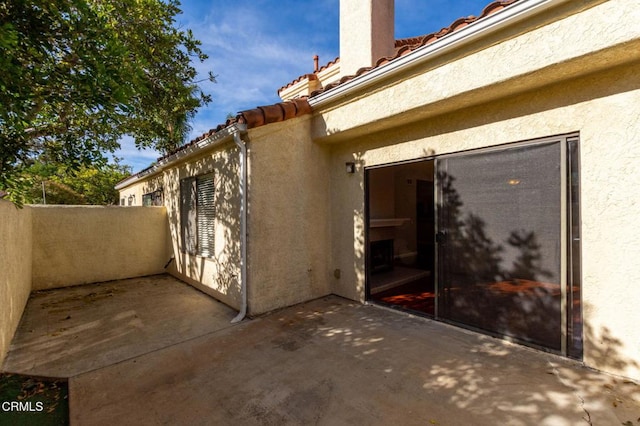 exterior space with a patio, a tile roof, and stucco siding