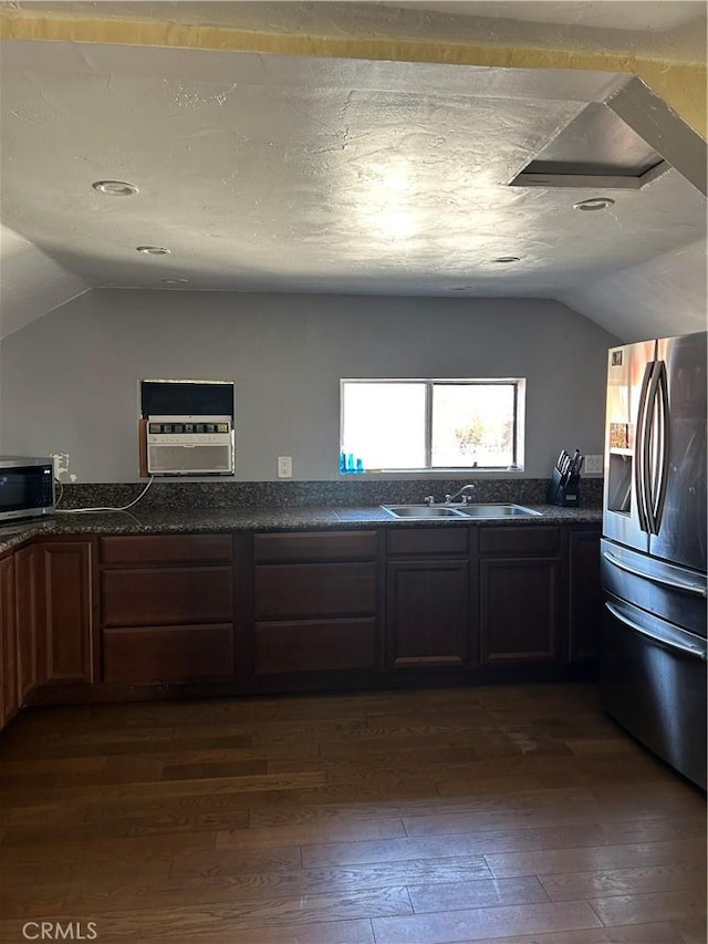 kitchen featuring vaulted ceiling, sink, appliances with stainless steel finishes, a textured ceiling, and dark hardwood / wood-style flooring