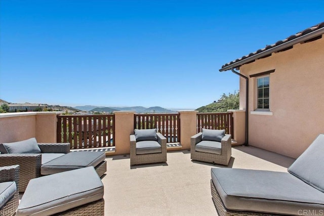 view of patio featuring a mountain view and a balcony