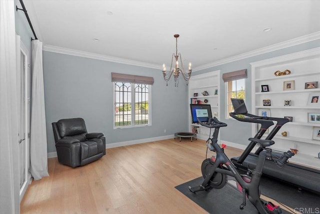 workout room featuring crown molding, built in shelves, an inviting chandelier, and light hardwood / wood-style floors