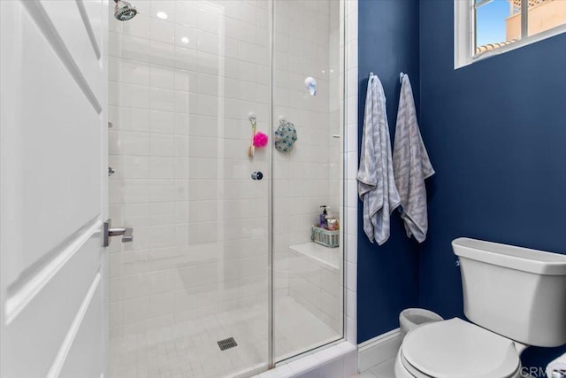 bathroom with toilet and an enclosed shower